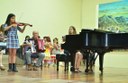 Estudante participando de apresentação do projeto "Musicalização Infantil através do violino e viola". Imagem disponível no SIGAA